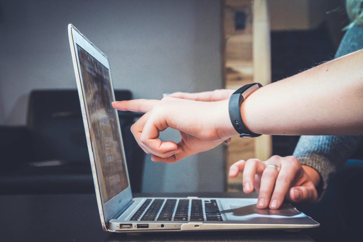 Hænder peger på laptop